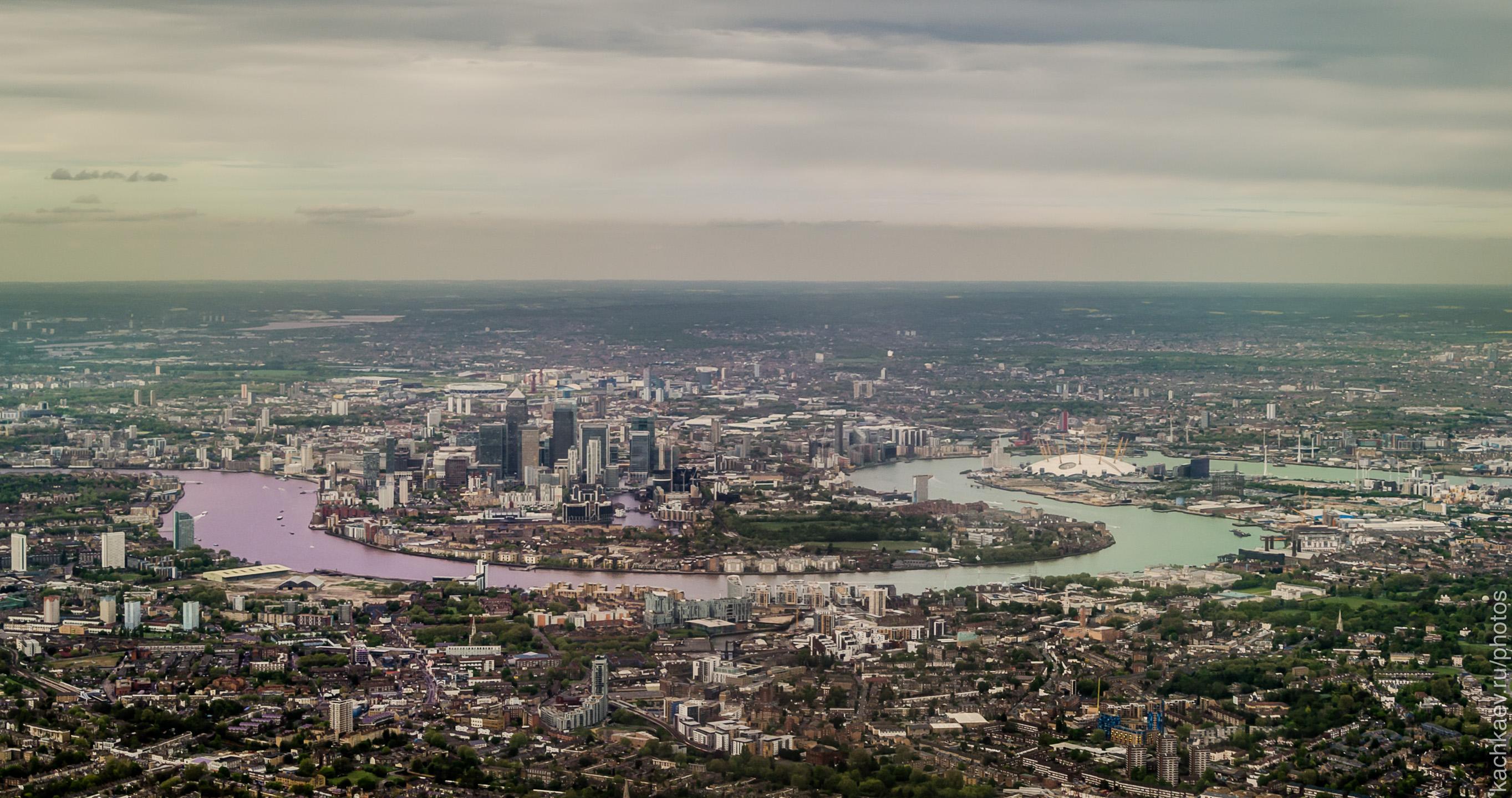 Real aerial photograph of Canary Wharf and the Isle of Dogs in London, with the River Thames, commercial towers and surrounding development.