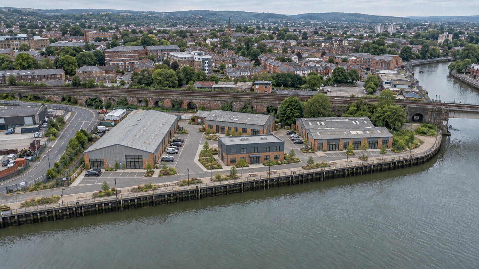 The same illustrative aerial viewpoint showing retained warehouses adapted for commercial use, modest infill, improved access, landscaping and quay frontage.