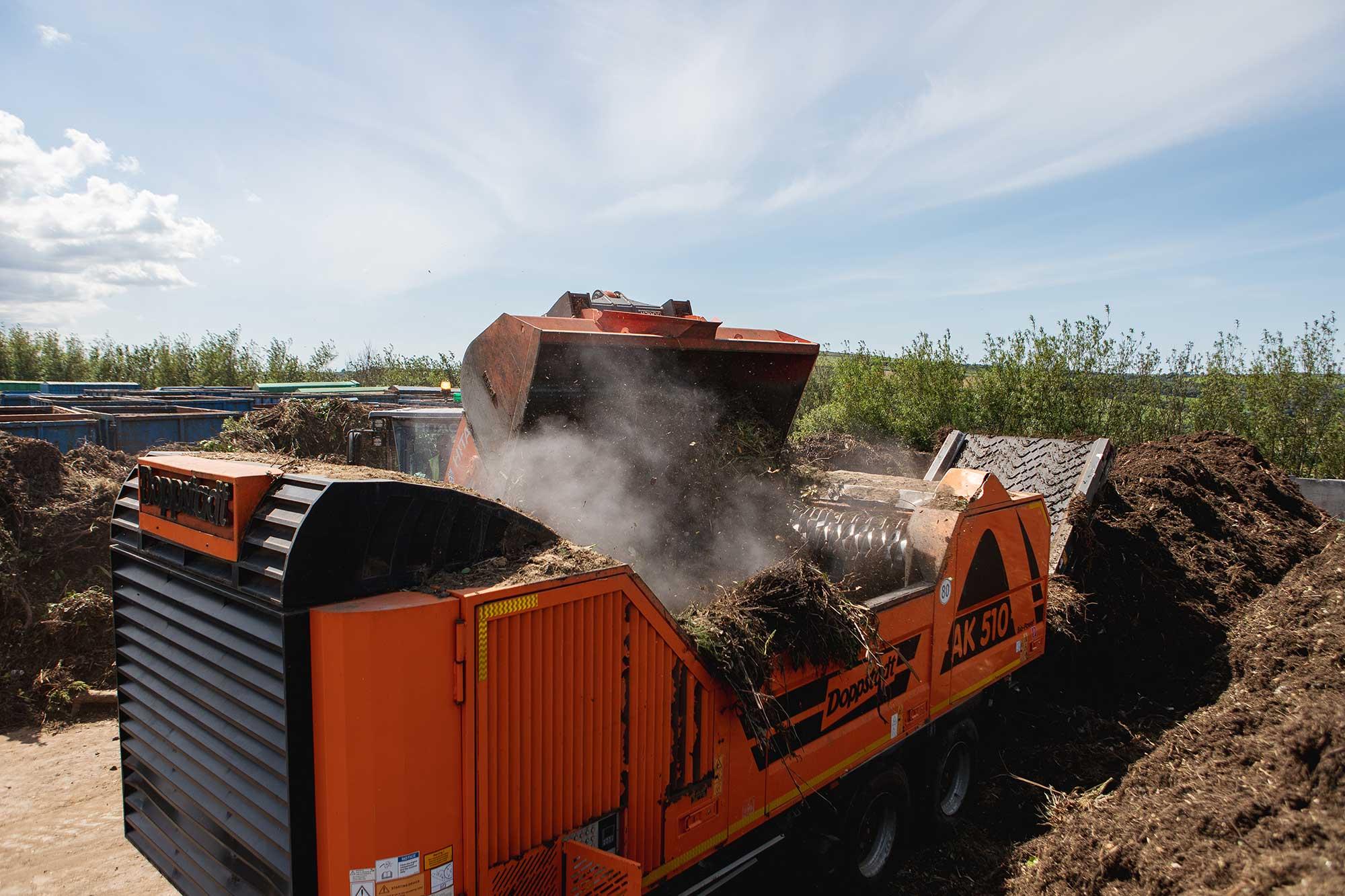 Real photograph from The Green Waste Company showing green waste being loaded into a Doppstadt shredder.
